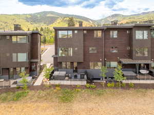 Rear view of property with a chimney, a patio, and a mountain view