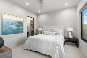 Bedroom with light carpet, recessed lighting, ceiling fan, and ensuite bathroom