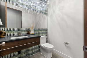 Half bathroom featuring vanity and toilet