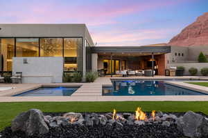Pool at dusk with a patio, an outdoor pool, and a fire pit