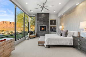 Carpeted bedroom with recessed lighting, wallpapered walls, and a tiled fireplace