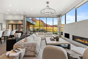 Living area with a tiled fireplace, a mountain view, recessed lighting, and expansive windows