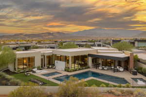 Back of house featuring an outdoor hangout area, a pool with connected hot tub, a patio area, and a mountain view