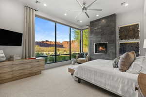 Bedroom with carpet floors, recessed lighting, a tile fireplace, and a ceiling fan