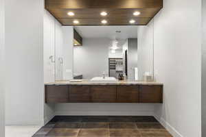 Full bathroom with recessed lighting, vanity, and dark tile patterned flooring