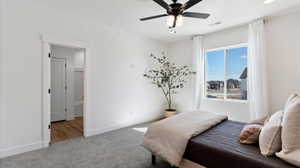 Carpeted bedroom featuring baseboards and ceiling fan