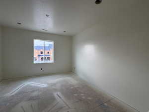 Unfurnished room featuring baseboards and a textured ceiling