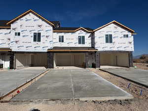View of front of house with concrete driveway and a garage