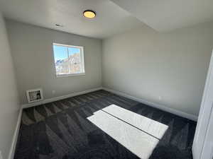 Spare room featuring carpet floors and baseboards