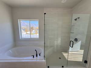 Bathroom featuring a shower stall and a garden tub