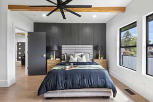 Master Bedroom with enginered wood floors, tastefull accent walls, wood beam ceiling, and lots of natural lighting.