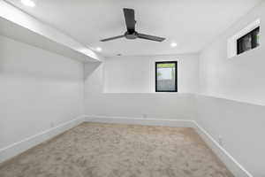 NW Basement bedroom features beautiful carpet, walkin closet, and ceiling fan.
