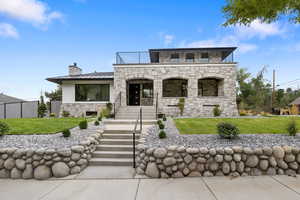 View of front facade featuring stone work, all new concrete everywhere and a large covered porch