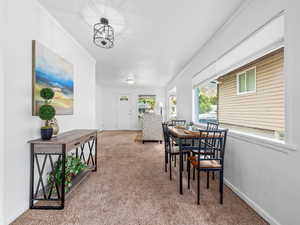 Dining space with light colored carpet and crown molding
