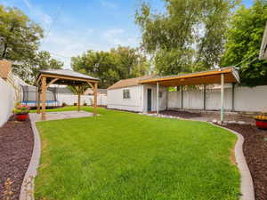 Rear view of house featuring a patio area, a gazebo, and a fenced backyard