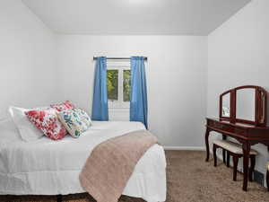 Bedroom featuring carpet and baseboards
