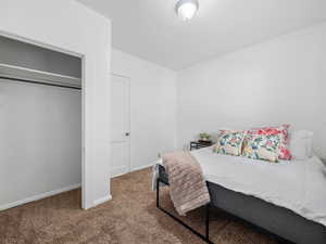Carpeted bedroom featuring baseboards and a closet