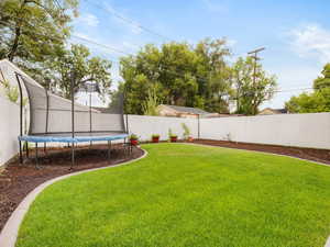 Fenced backyard with a trampoline