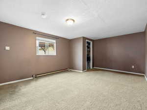 Separate structure from the house. She Shed or a Man Cave with a baseboard heating unit, carpet, closet, textured ceiling