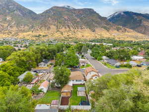 Aerial view of property and surrounding area featuring nearby suburban area and a mountainous background