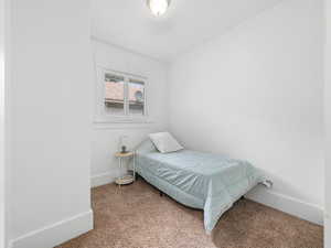 Carpeted bedroom with baseboards and a closet