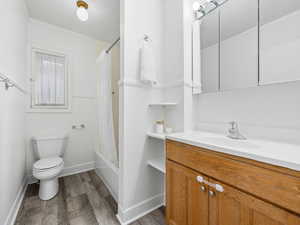 Bathroom with shower / bath combo, vanity, and dark wood finished floors