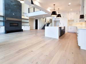 Kitchen with open floor plan, white cabinets, light wood finished floors, and recessed lighting