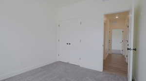 Unfurnished bedroom with carpet, a closet, and recessed lighting