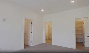 Unfurnished bedroom with a spacious closet, recessed lighting, and carpet floors