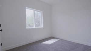 Carpeted spare room with baseboards