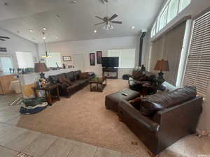 Living room featuring ceiling fan, vaulted ceiling, light tile patterned flooring, recessed lighting, and light carpet
