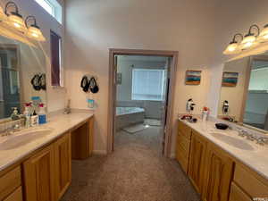 Full bath featuring two vanities, a garden tub, and dark carpet