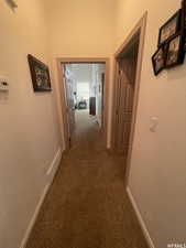 Hall with carpet and a textured wall