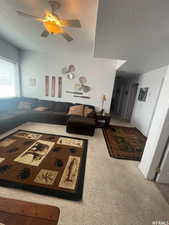 Living room featuring carpet, a textured ceiling, and a ceiling fan