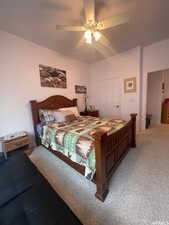 Carpeted bedroom featuring ceiling fan