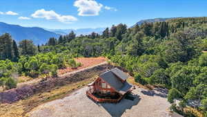 View from above of property featuring a mountainous background and a forest