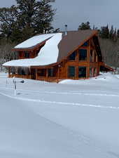 Snow covered property featuring a porch