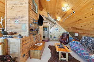 Carpeted bedroom with wood walls, wooden ceiling, and lofted ceiling