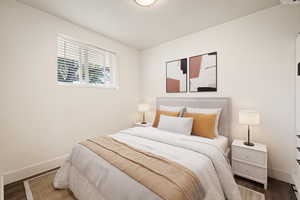 Bedroom with wood finished floors and baseboards