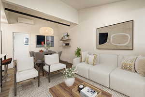 Living room featuring wood finished floors and a wall mounted AC