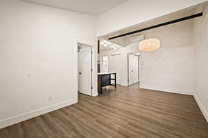Unfurnished living room featuring dark wood-style floors and an AC wall unit