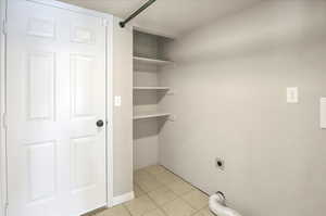 Laundry room with electric dryer hook up, build in shelves, entrance to garage