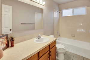 Full bath with bathtub / shower combination, vanity and light tile flooring