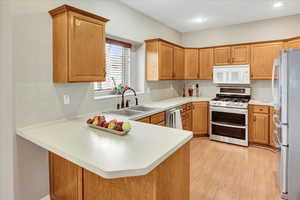 Kitchen featuring all appliances included. Newer Gas Range with double oven and Refrigerator.  Window view to back yard
