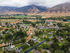 Aerial view of property and surrounding area with a mountainous background and nearby suburban area