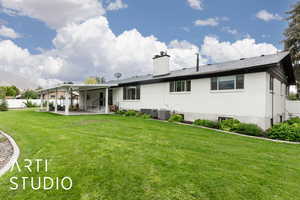 Rear view of house featuring a patio and a chimney