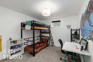 Bedroom with light carpet and an office area
