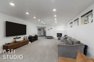 Living room featuring light colored carpet, recessed lighting, and a brick fireplace