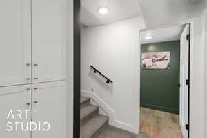 Stairs featuring wood finished floors and a textured ceiling