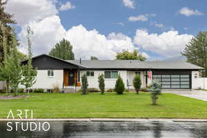 Single story home featuring a front yard, driveway, and an attached garage